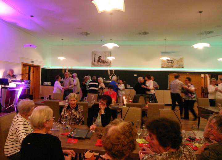 Sicht in den Speisesaal mit vielen besetzten Tischen, Abendstimmung