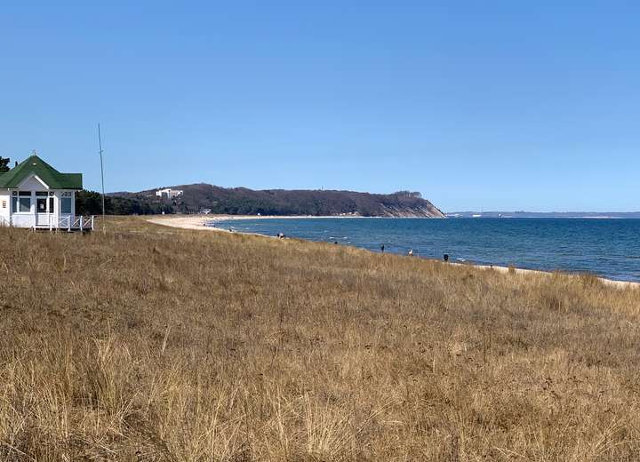 Blick auf das Meer, den Strand und das historische Strandhäuschen von Göhren bei einem sonnigen Tag