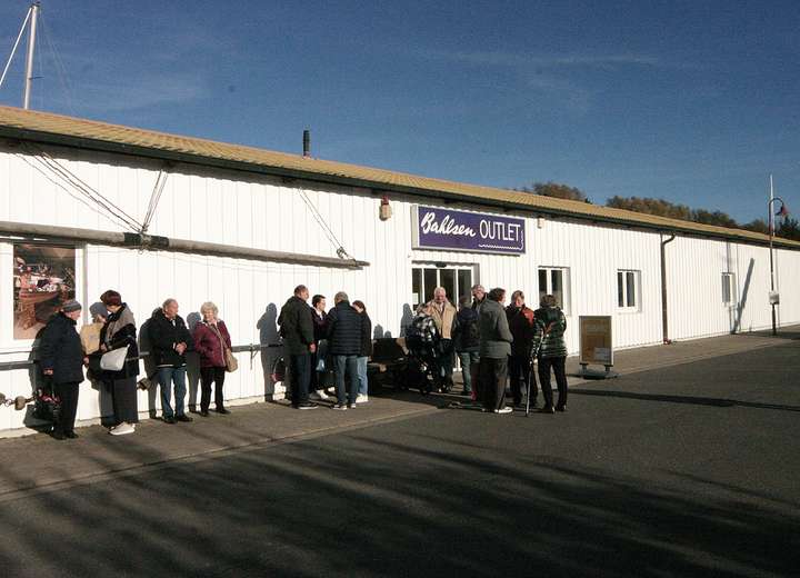Sicht auf den Eingang Bahlsen Outlet, eine Traube Menschen warten auf den Einlass