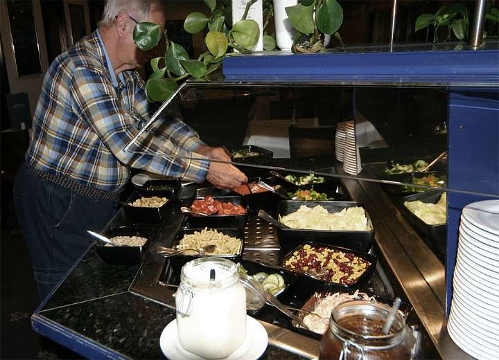 Ansicht Buffet, ein Herr greift kräftig zu