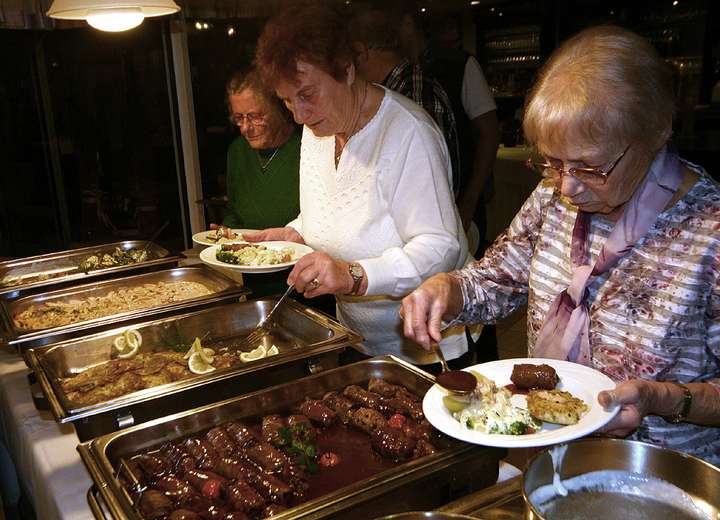 Ansicht Buffet, zwei Frauen greifen kräftig zu