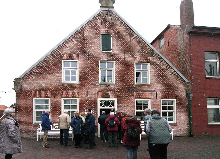 Ansicht des Kapitäns Hauses, vor dem Eingang steht eine Traube von Menschen