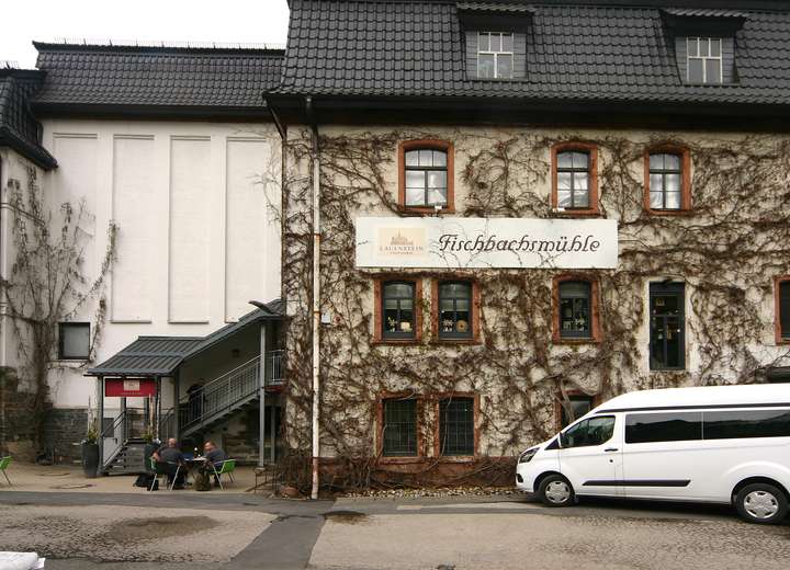 Ansicht auf den Eingang der Lauenstein Produktionsstätte, der zugewachsen ist mit Efeu bis zum Dach