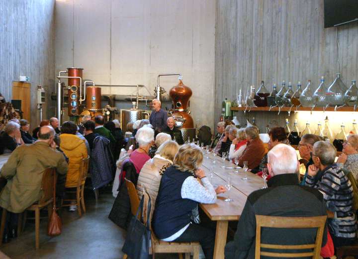 Gäste am Tisch verkosten direkt in der Brennerei Herz