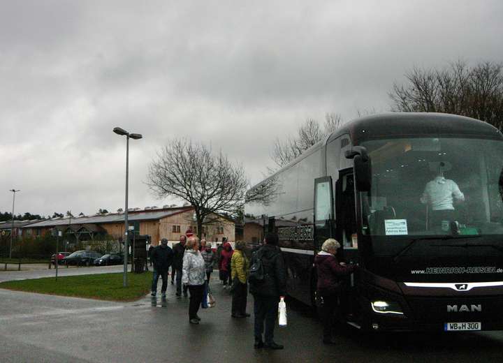 Menschengruppe steigt wartend und geordnet in den Reisebus
