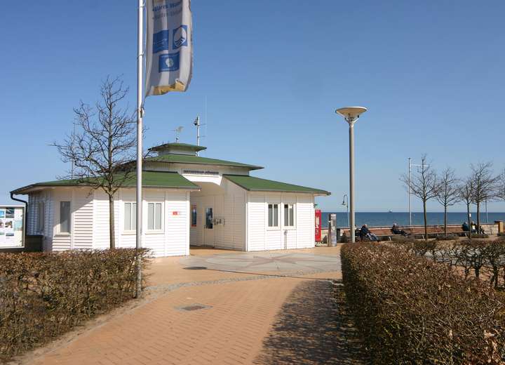 Blick auf einen Holzpavillon in weißer Farbe mit wehender Rügen Fahne, der Pavillon ist historisch