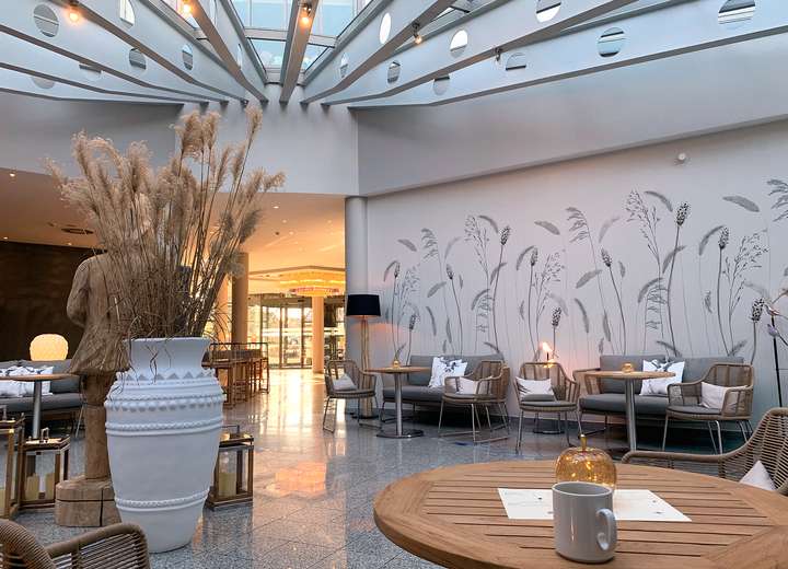 Sicht auf die großzügige Lobby des Hotels, die sonnengeflutet einlädt, Platz in den Sitzgelegenheiten zu nehmen