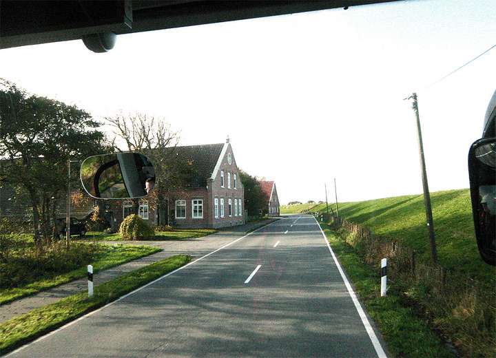 Blick auf vorbeiziehende Häuser aus einem fahrenden Bus