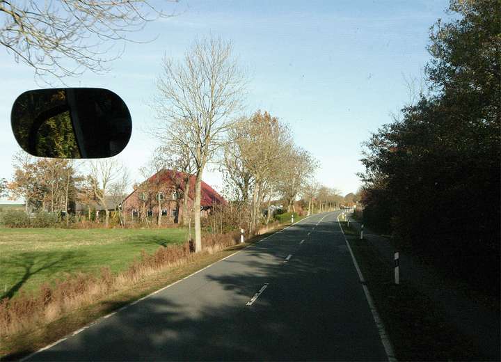 Blick auf die Landstraße aus einem fahrenden Bus